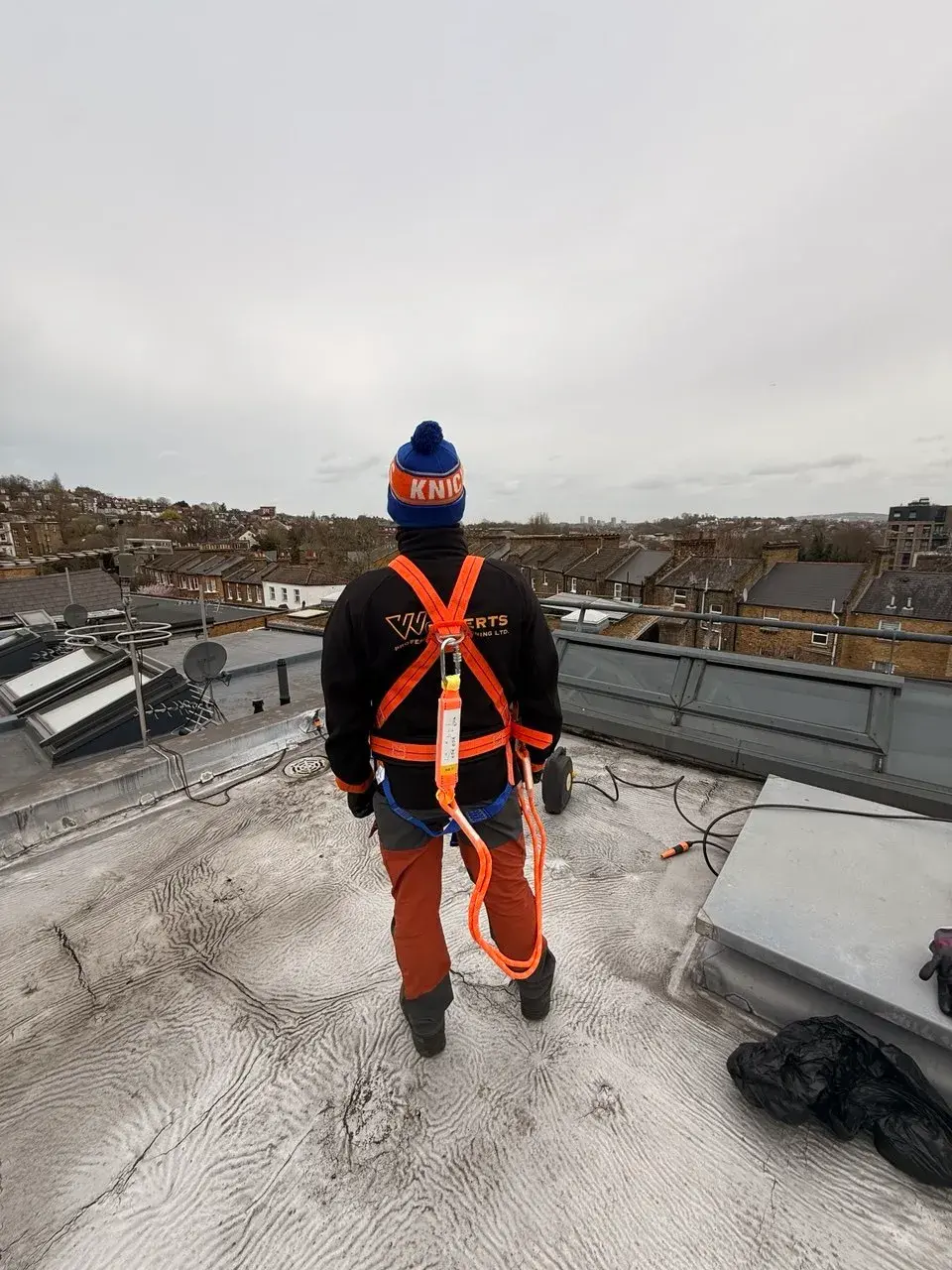 A WrXperts team member in branded uniform on a London rooftop